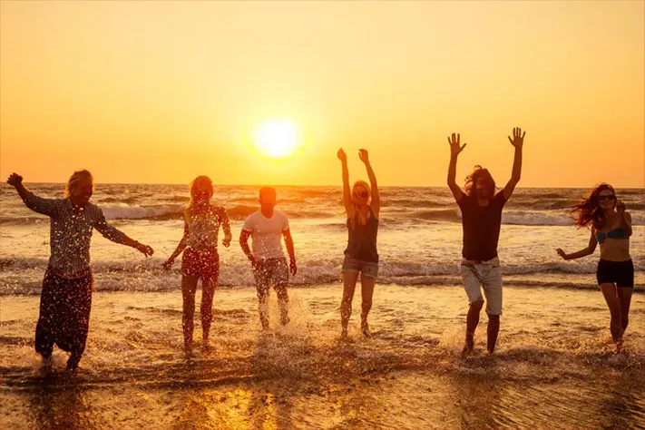海で学生たちが仲間と遊ぶ様子